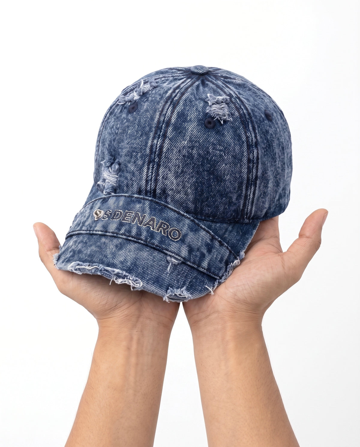 Denaro Denim Cap in washed blue denim held in hand