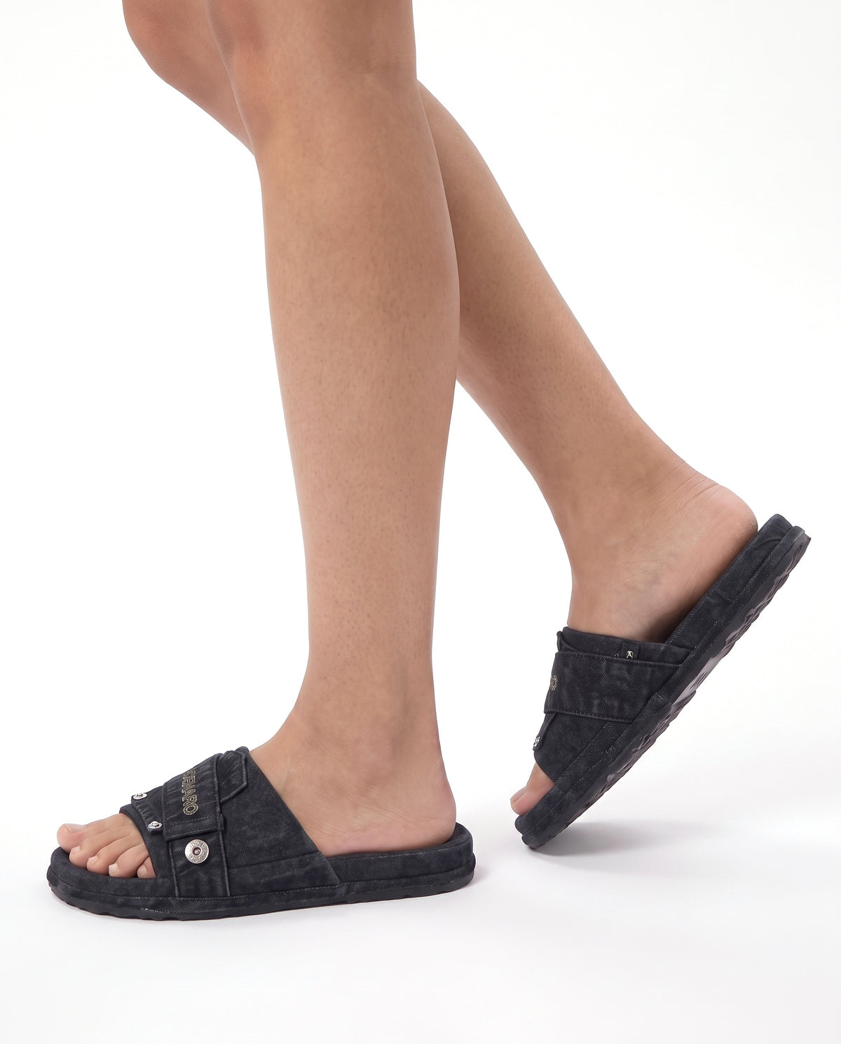 Model wearing the Denaro Denim Slide in black washed denim, mid-step