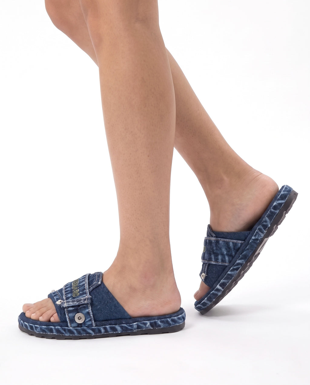 Model wearing the Denaro Denim Slide in deep indigo denim, mid-step